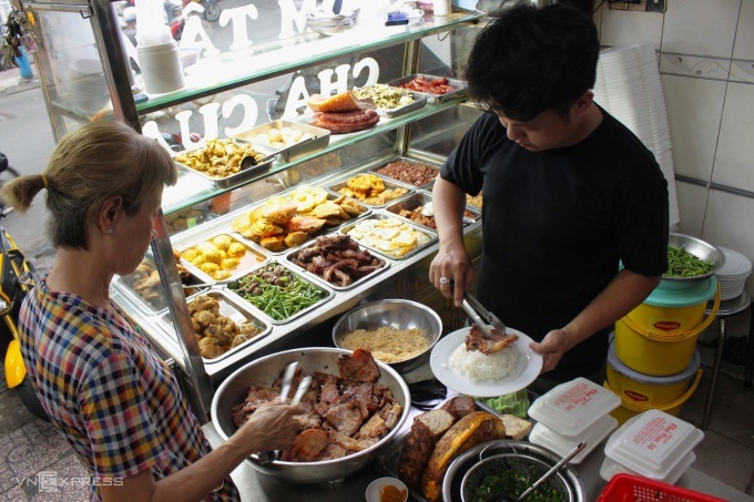 Diners can choose various toppings to accompany their broken rice, ranging from pork rib to meatball, egg, and Chinese sausage. Photo by VnExpress/Huynh Nhi
